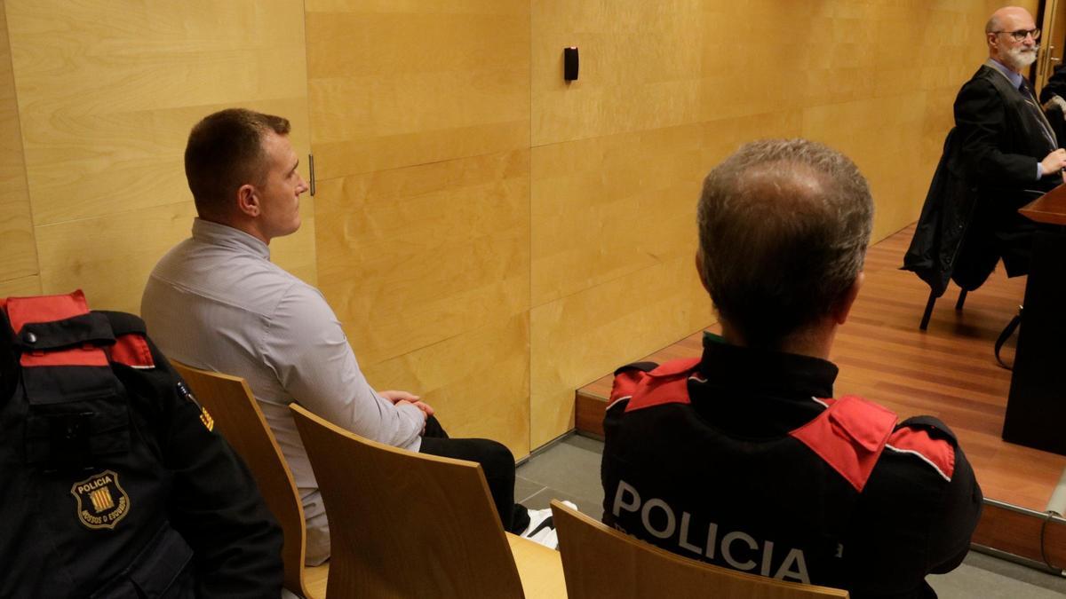 L'acusat de l’assassinat de la seva parella a Campdevànol, a l’esquerra, acompanyat d’un agent dels Mossos d’Esquadra.