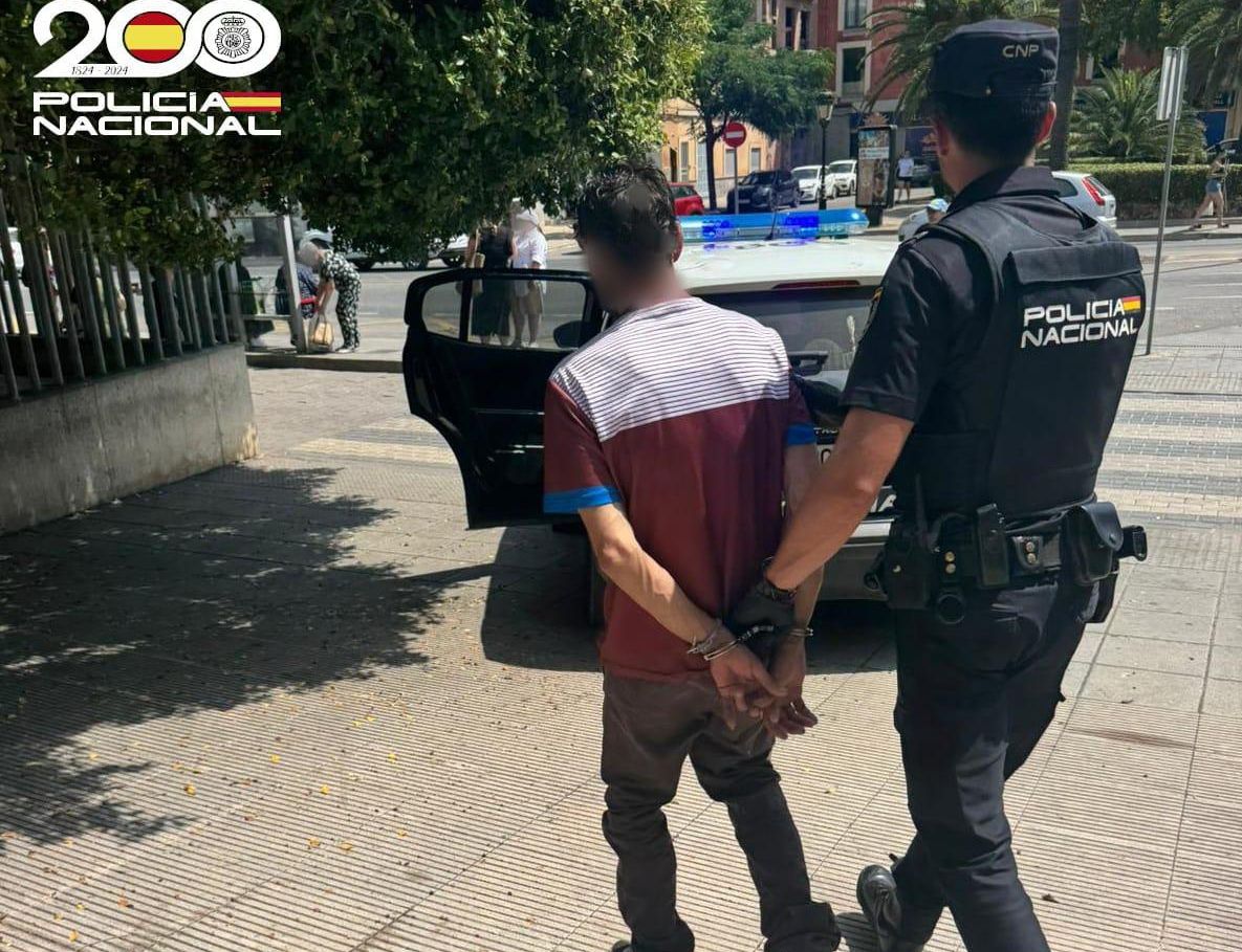 Un policía custodia al hombre detenido por provocar el incendio en Manacor.