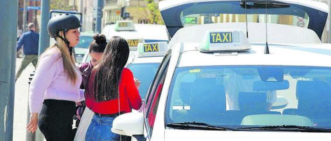 Varias personas acceden a un taxi en la parada del puerto de Eivissa. | J. A. RIERA