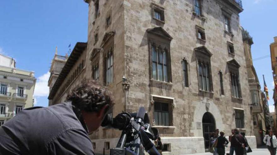 Un cámara de televisión graba el Palau de la Generalitat.