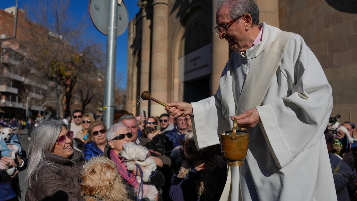El párroco de la iglesia de San Andreu Palomar bendice a los animales durante la tradicional cabalgata de los Tres Tombs en Barcelona.