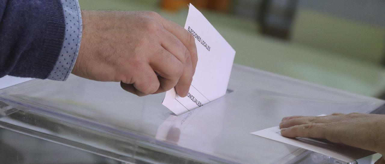 Un elector deposita una papeleta en una urna