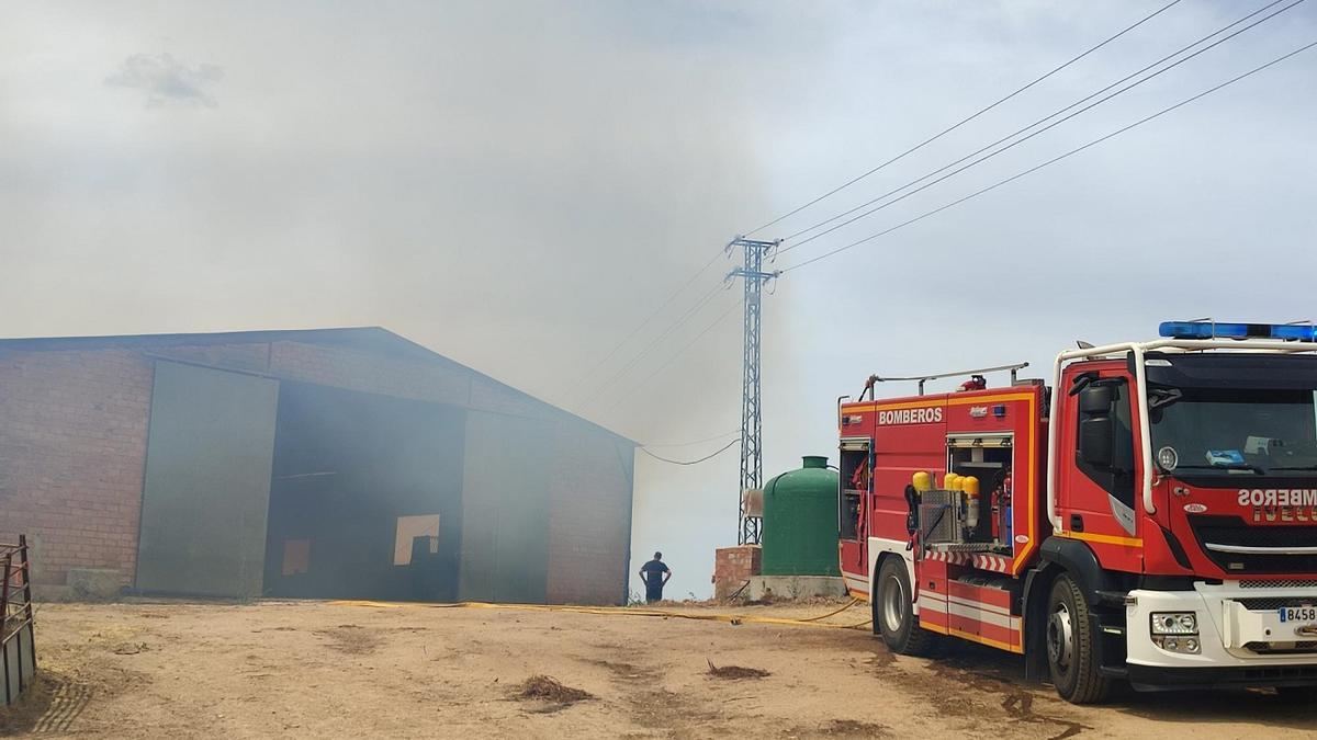 Un vehículo de los bomberos, este martes ante la nave agrícola que ha sufrido el incendio en Pedroche.