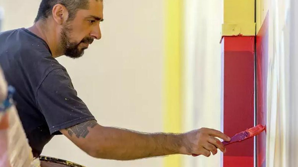 Inti dibujando un mural.