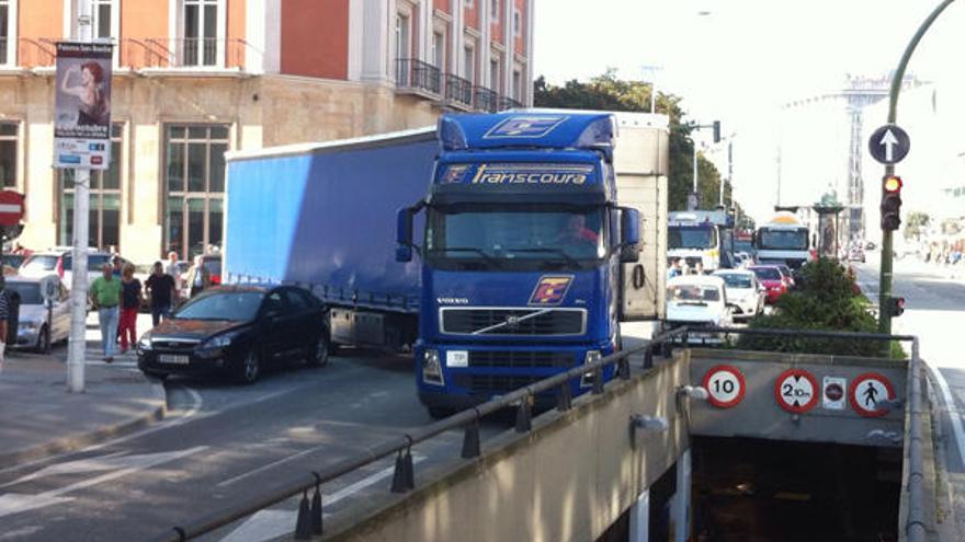 El camionero maniobra para &#039;librar&#039; del vehículo mal aparcado.