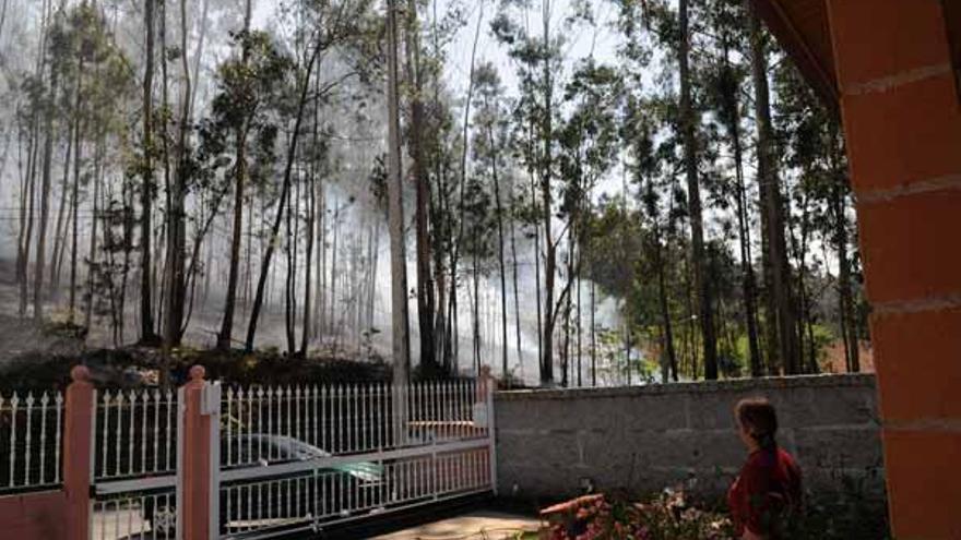 Un incendio forestal cerca un núcleo de viviendas en el lugar de Fragamoreira