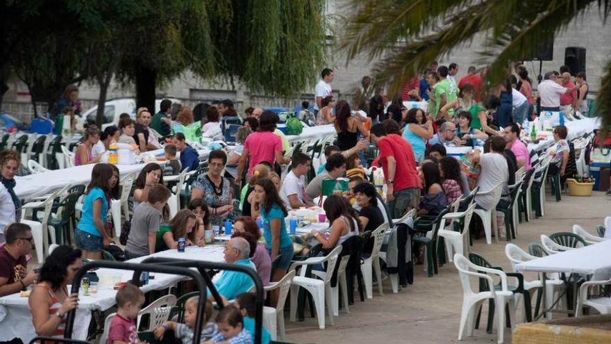 Varios vecinos disfrutan de la comida en la calle el pasado año.