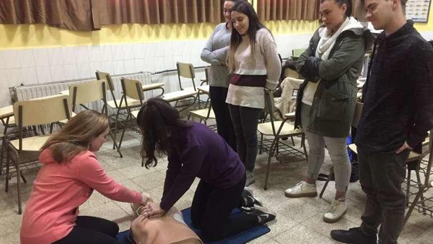 Adela Iglesias y Yara Flórez ponen un desfibrilador al muñeco, ante la mirada de Rubén Pedrosa, Andrea Rodríguez, Elena Pérez y Sofía Arango.