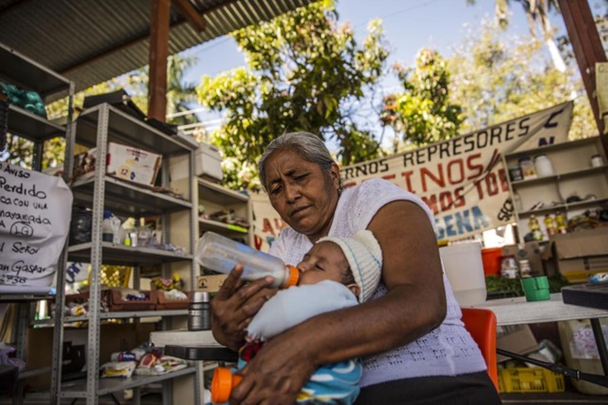 Delfina de la Cruz es la madre de Adán Abraján y lleva en brazos a su sobrino Ricardo. Delfina vive cerca de la Escuela y por eso duerme en su casa. Cuando no está en el Polideportivo se encuentra en algún acto reivindicando por la aparición de los estudiantes.