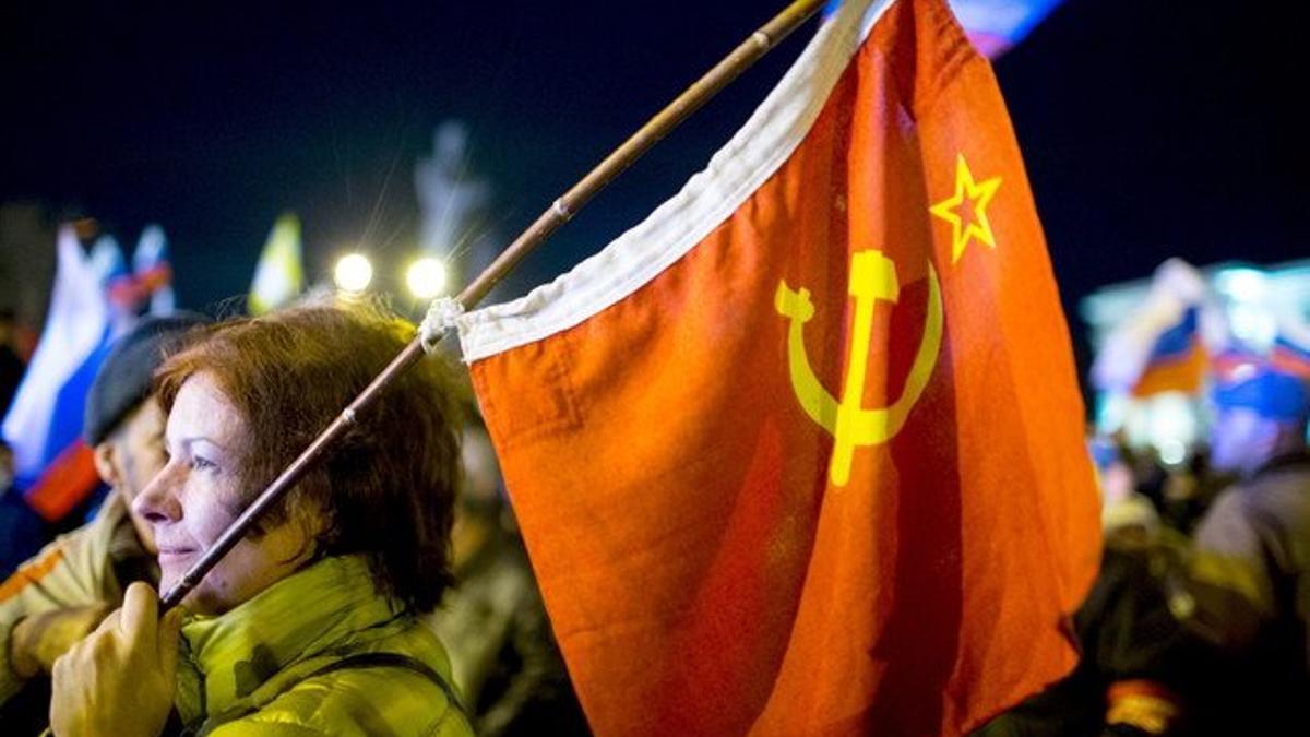 Una mujer sostiene una bandera soviética en la plaza de Lenin, en Simferopol, este domingo.