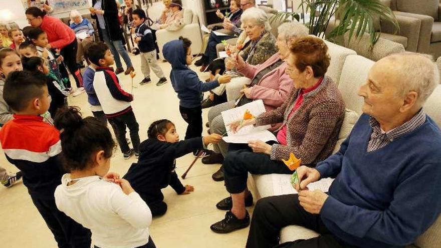 Los niños entregan sus manualidades a los mayores. // Marta G.Brea