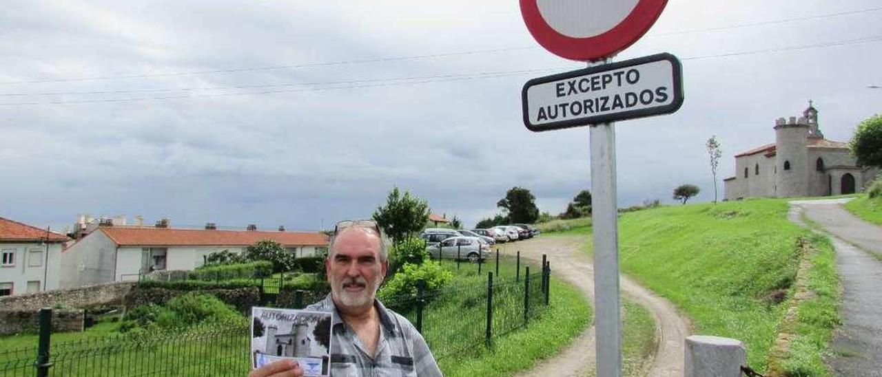 Morán, con la autorización en la mano, y el aparcamiento y la capilla de la Guía al fondo, ayer.