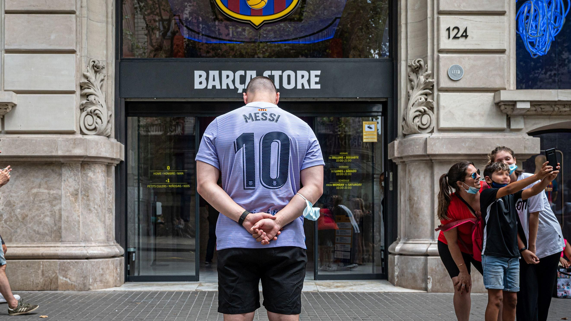 Un joven alemán con la camiseta de Messi frente a la tienda del Barça en Las Ramblas