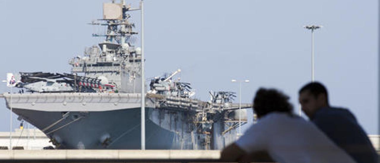 Dos personas observan el USS Iwo Jima desde la Marina Real, ayer.