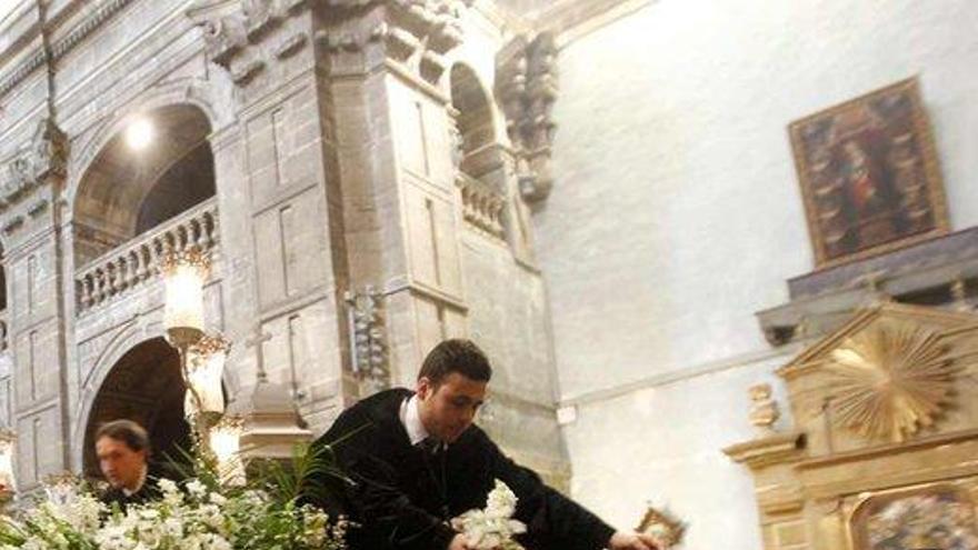 flores para el recuerdo. Al término de la procesión, los cofrades repitieron la tradición de repartir entre los fieles las flores que adornaban el paso de la Señora de Oviedo. | luisma murias