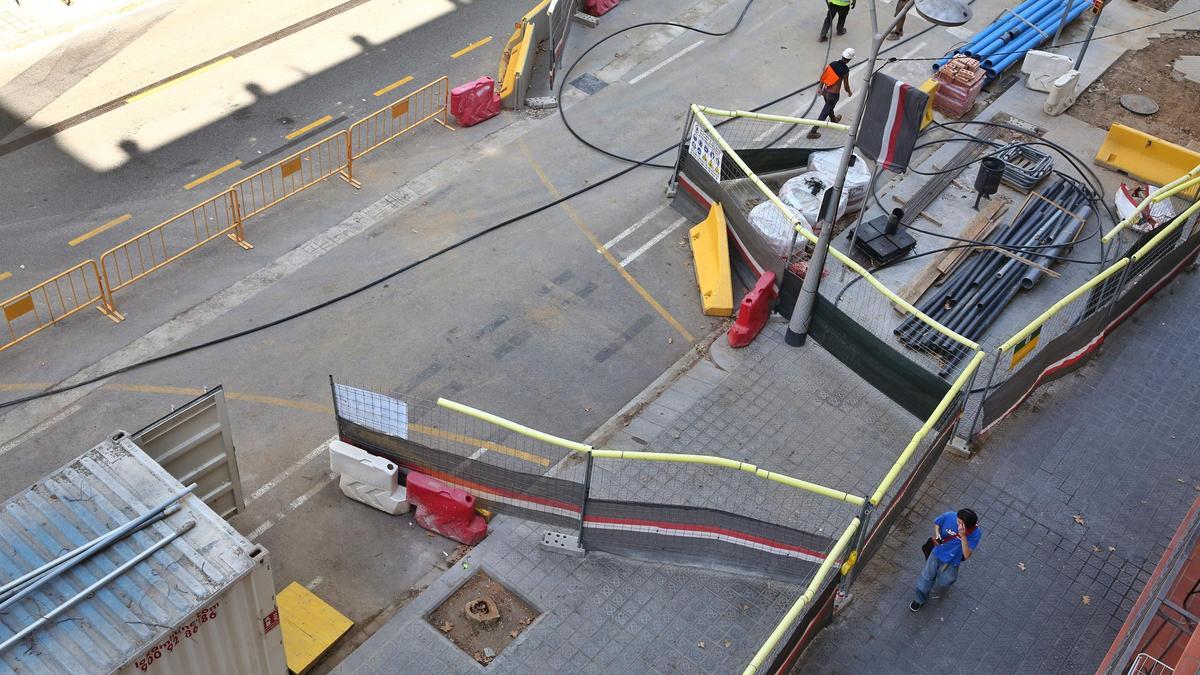 Vista de las obras de la calle de Urgell, con los restos de un árbol talado en medio, el pasado míercoles.