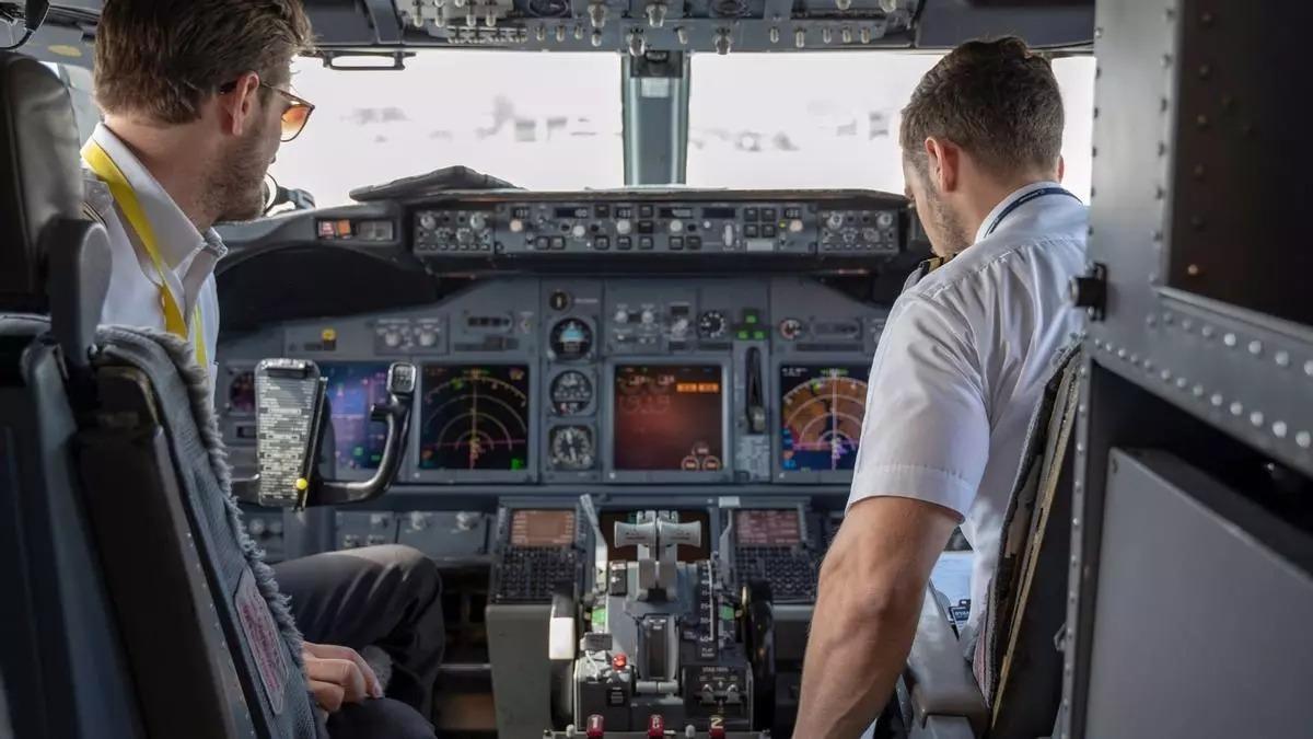 Imagen de dos pilotos en la cabina de un avión.