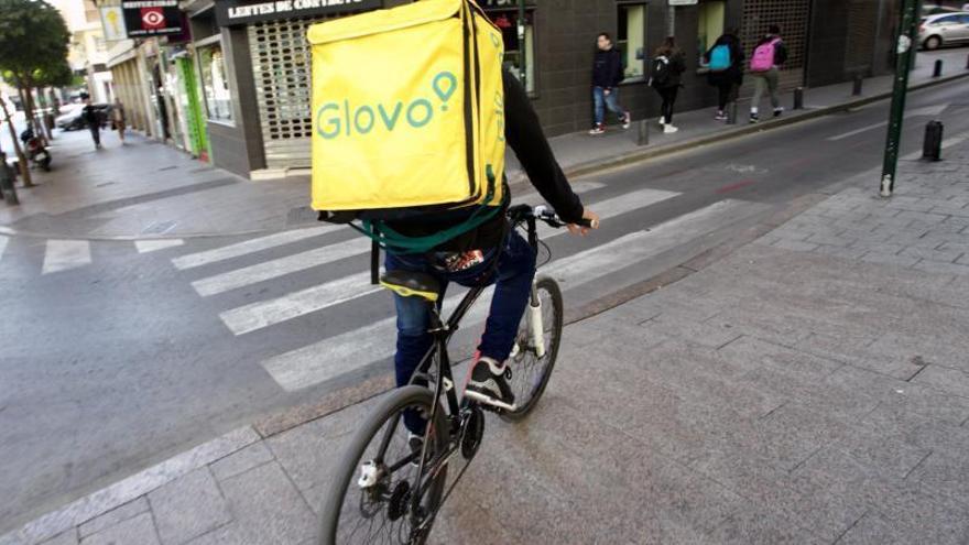 Un repartidor de Glovo circula con su mochila por una calle de Murcia. | JUAN CARLOS CAVAL