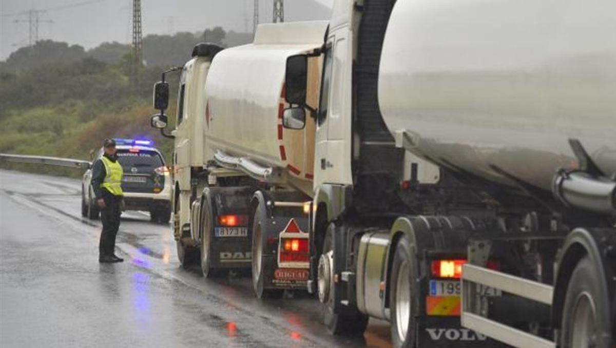 Un vehículo de la Guardia Civil abre paso a un convoy de cisternas para evitar el bloqueo de los piquetes.