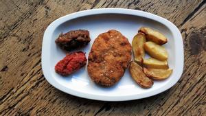 El plato de filete ruso con cebolla, patatas y compota de tomate.