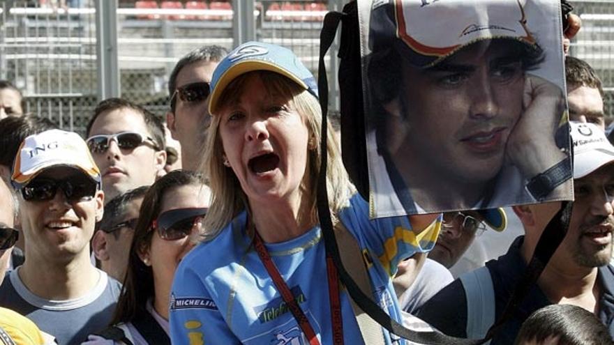 Varios aficionados del piloto de Renault Fernando Alonso animan al asturiano