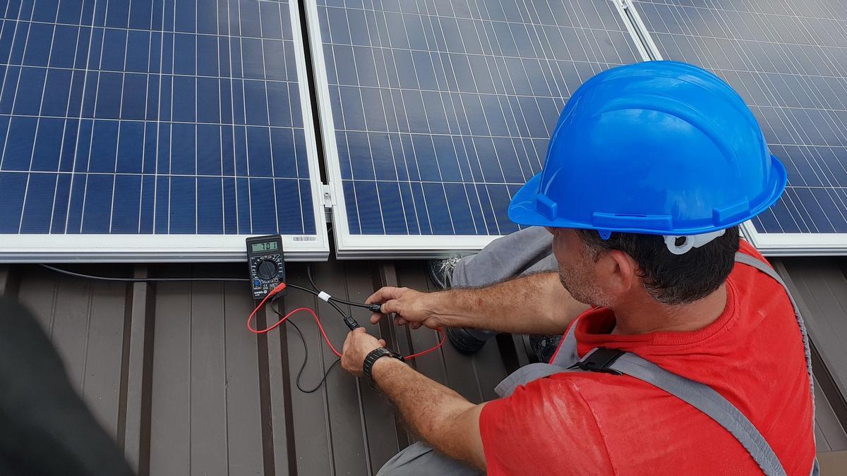 Un instal·lador en un projecte de solar fotovoltaica