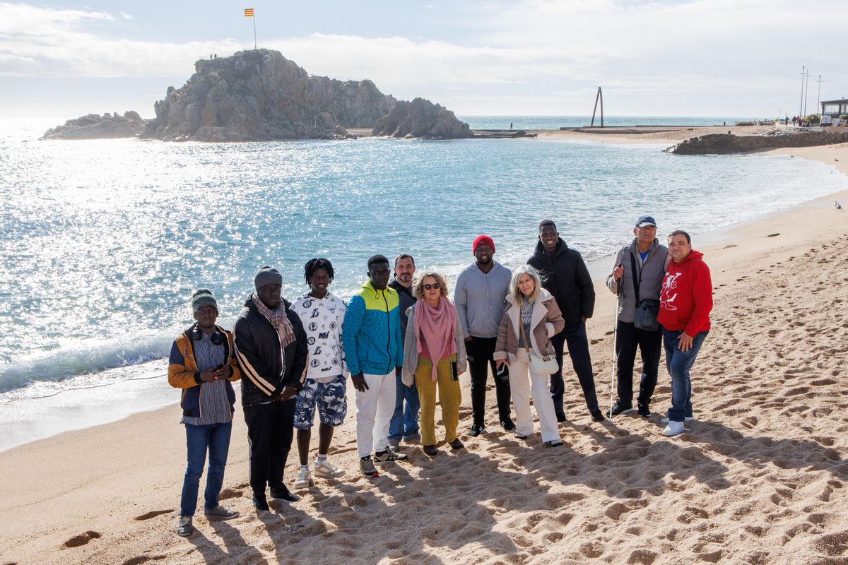 Voluntarios de la asociación Sostre i Dignitat, y migrantes alojados en los hoteles de Blanes, el pasado lunes en la playa de esta localidad.