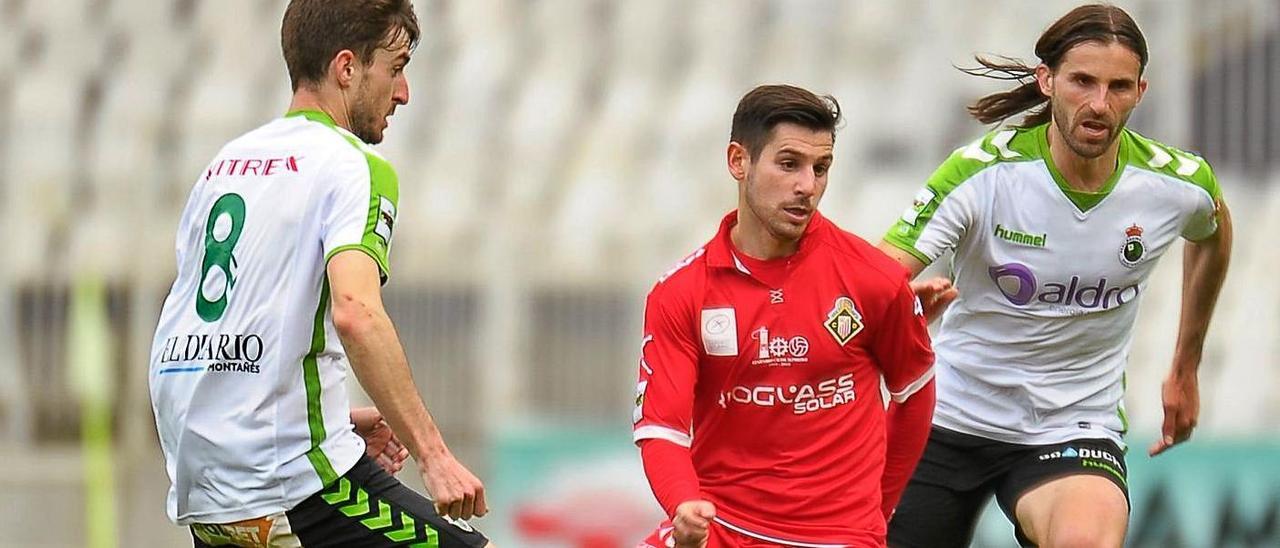 Jandrín, entre el azulgrana Gonzalo y Rivero, en un Racing de Santander-Caudal. |