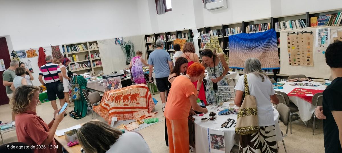 Vecinas y vecinos acuden al mercadillo organizado por la Asociación África Acoge celebrado en la biblioteca de Villanueva del Campo.