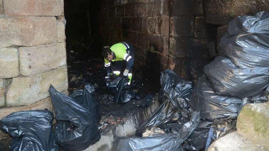 Un operario del servicio de limpieza del Concello limpia el puente tras el incendio. // Rafa Vázquez