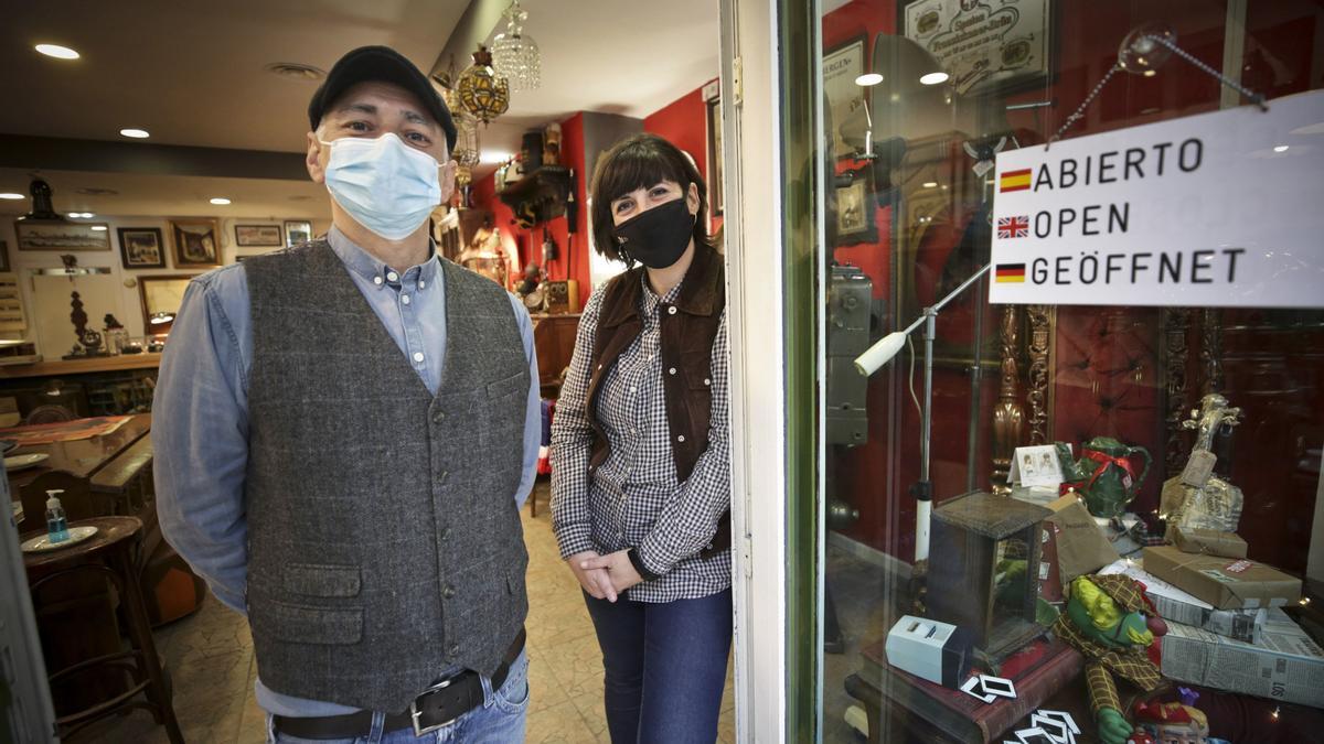 Los propietarios de la tienda de antigüedades de la calle del Rosal de Oviedo posan frente a su establecimiento