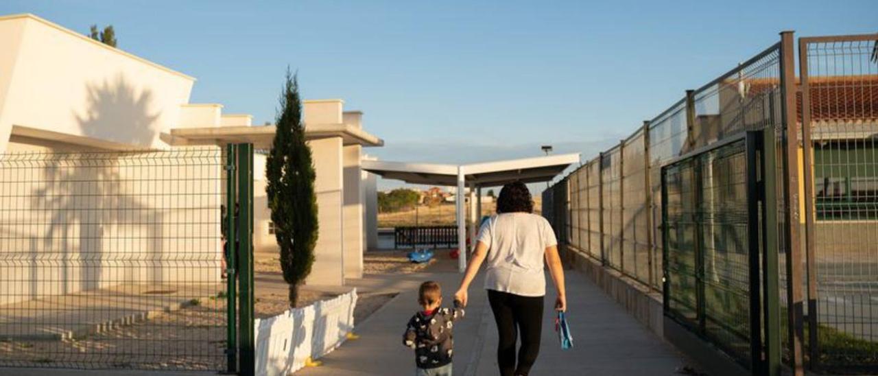 Una mujer, con su hija de la mano, de camino al colegio de Roales.