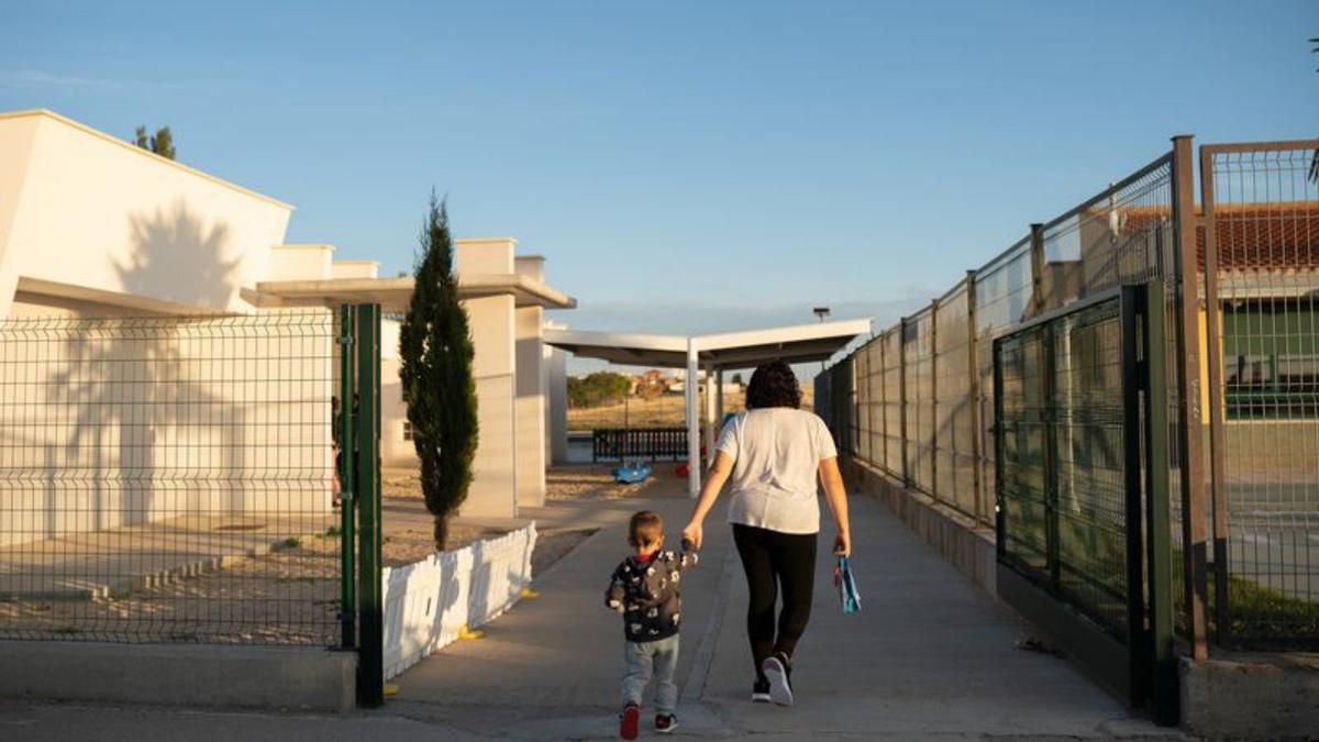 Una mujer, con su hija de la mano, de camino al colegio de Roales.