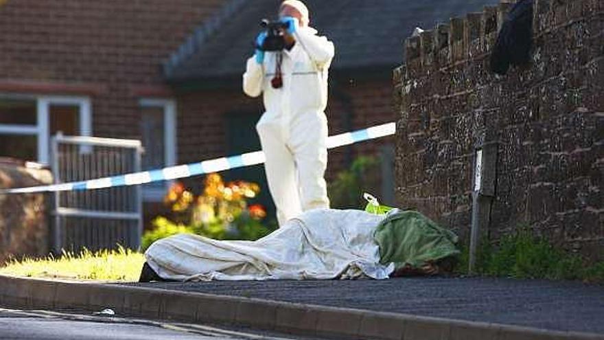 Un policía forense graba en vídeo imágenes de un cadáver. / reuters