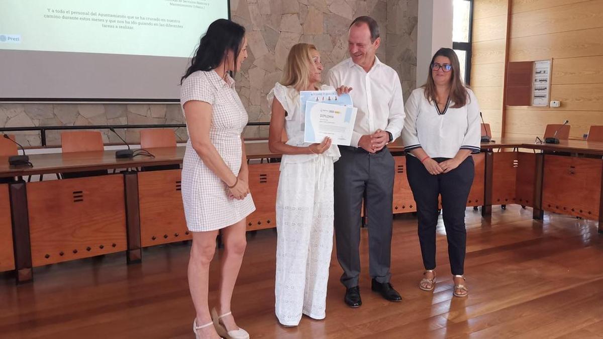 La concejala de Parques y Jardines, Juani Martel; el alcalde de Agüimes, Óscar Hernández y la concejala de Desarrollo Local, Catalina Suárez; durante la entrega del diploma a una de las alumnas graduadas.