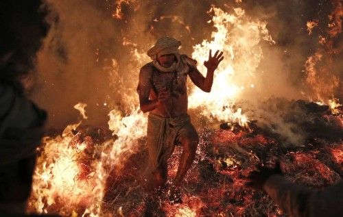 Hindu priest Babulal jumps out of a fire to signify the burning of the demon Holika during a ritual to mark the first day of the Holi at village Phalen