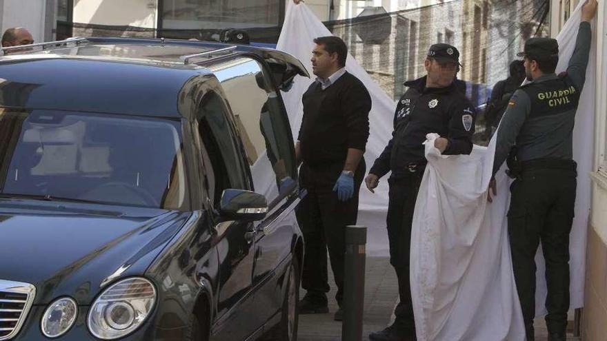 Varios agentes colocan lonas en el lugar donde fueron hallados los fallecidos. // Efe