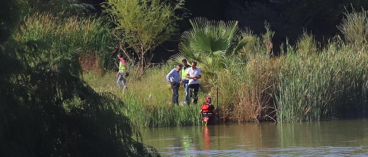 Los bomberos buscan al desaparecido en el río.