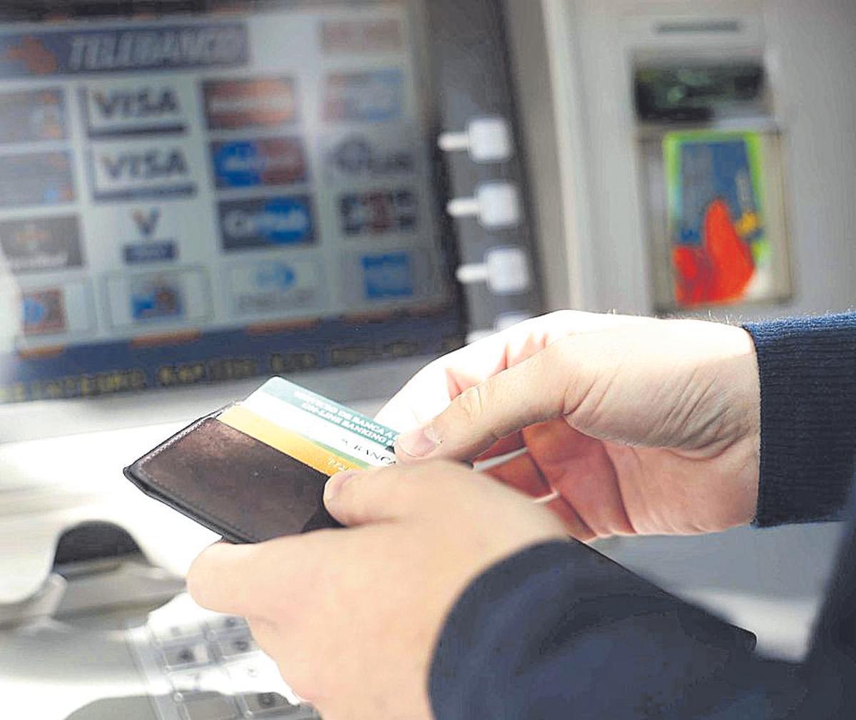 Un cliente saca dinero de un cajero