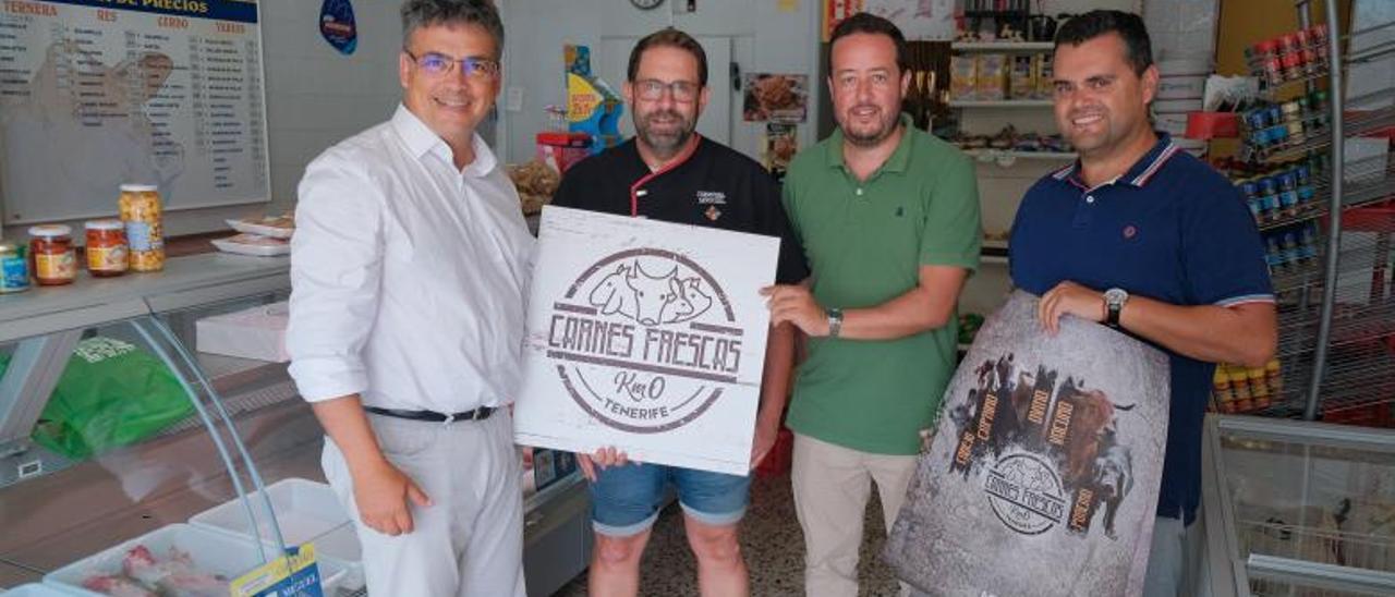 El conesejero del Cabildo Javier Parrilla, a la izquierda, entrega uno de los certificados de carne fresca de Tenerife. | | E.D.