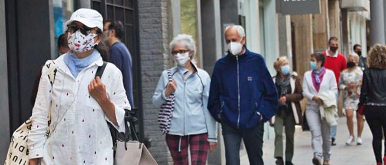 Personas con mascarilla paseando por la calle