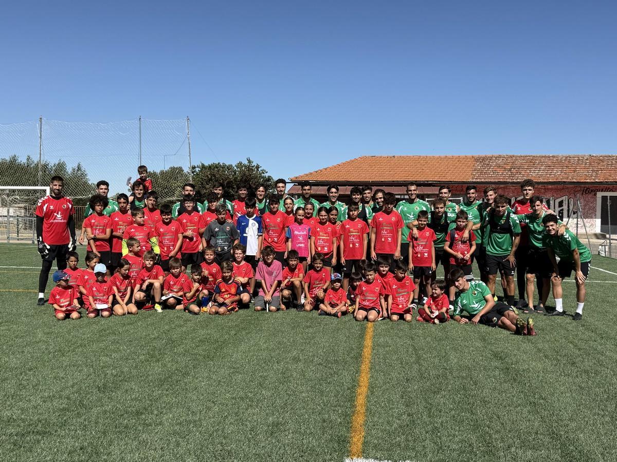 Los jugadores del Cacereño posan con los chicos de la escuela de fútbol de Piornal.