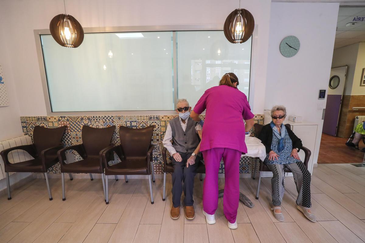 Una enfermera vacuna a dos personas mayores en València, en una imagen de archivo.