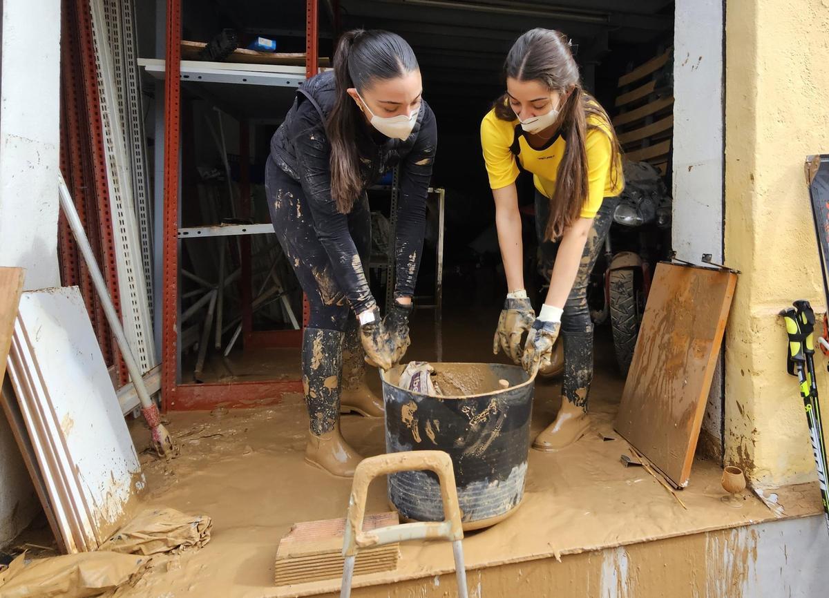 Carla Marcos y Beatriz Navarro sacan barro del domicilio de la segunda, en el Forn d'Alcedo