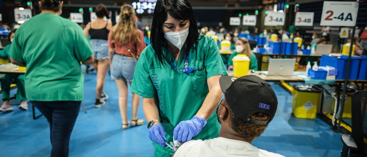 Una sanitaria vacuna contra la Covid en el Pabellón Santiago Martín.