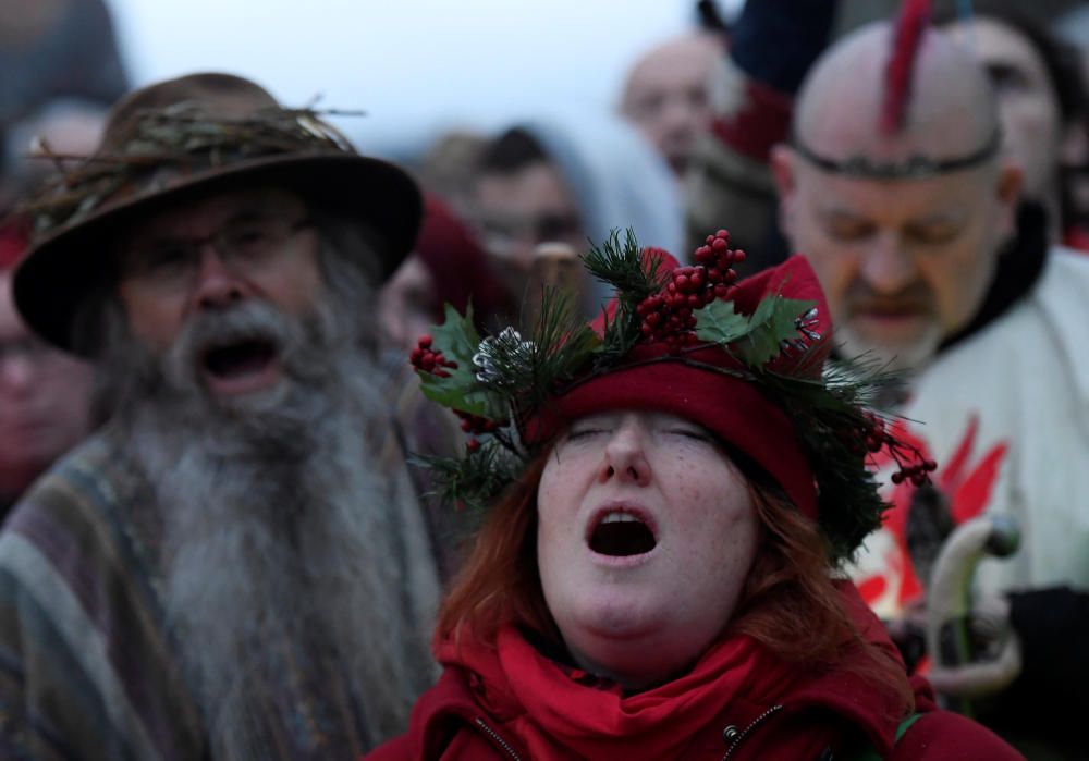 Miles de personas, varias de ellas disfrazadas de druidas, acudieron hoy al monumento de Stonehenge en Inglaterra para ver el amanecer con motivo del solsticio de invierno.