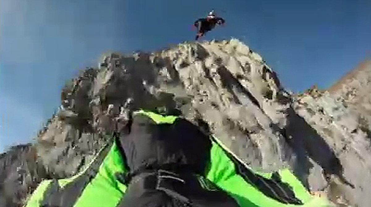 Dos saltadors baixen per un penya-segat, gairebé fregant les roques.