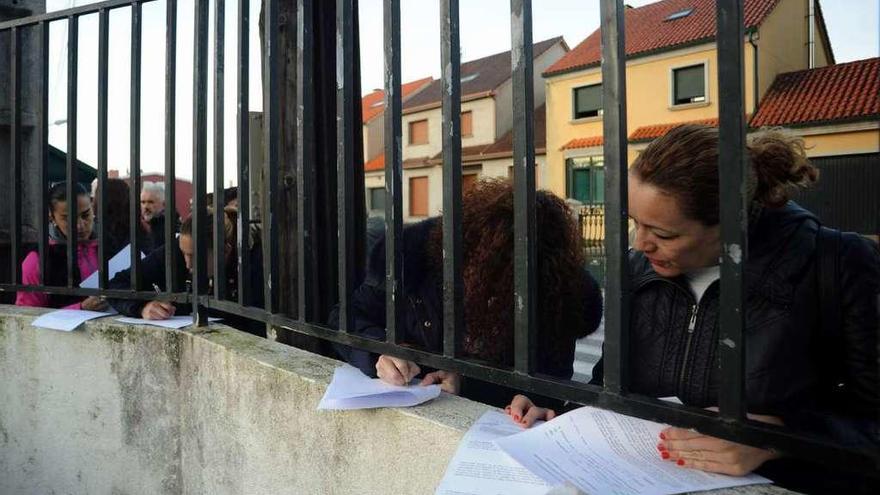 Madres rubricando el escrito en el que se exponen los motivos del rechazo al doble turno. // Iñaki Abella