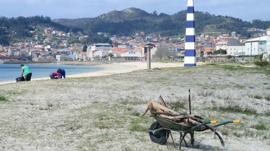 Trabajadores realizando tareas de limpieza en la playa de Rodeira, la pasada primavera . // G. Núñez