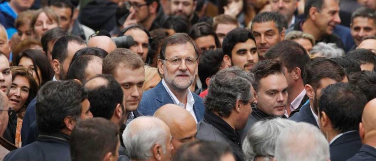 Rajoy entre el gentío que le acompañó en su ruta canguesa, y la protesta mínima, a mucha distancia del Presidente y entre policías.